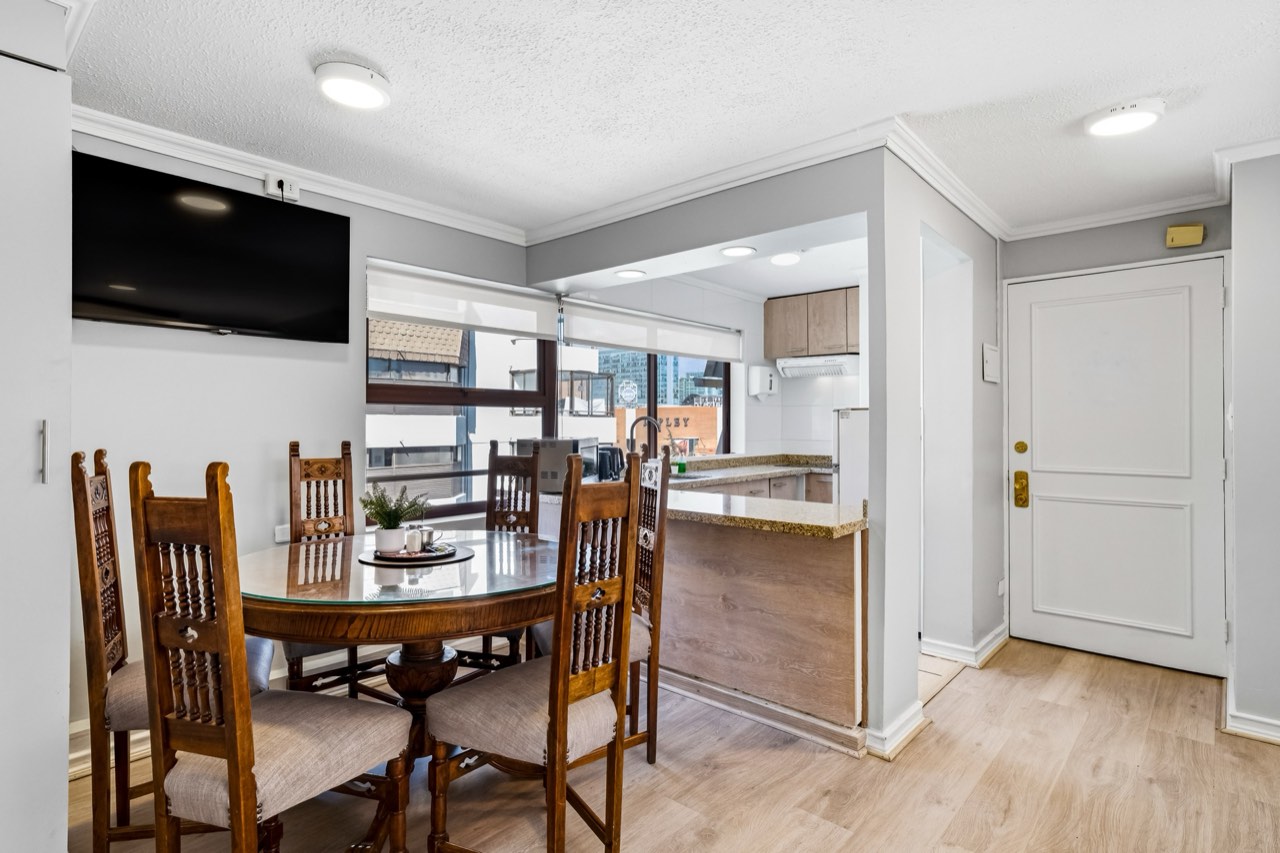 Comedor con mesa redonda y vista a cocina - Suite 1001 Suites Vitacura