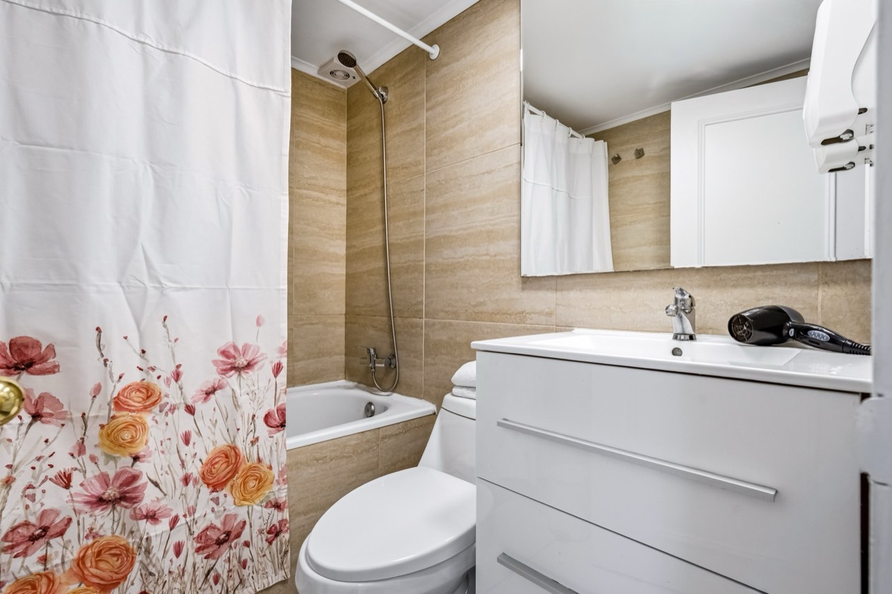 Baño con tina y vanitorio moderno - Suite 1001 Suites Vitacura