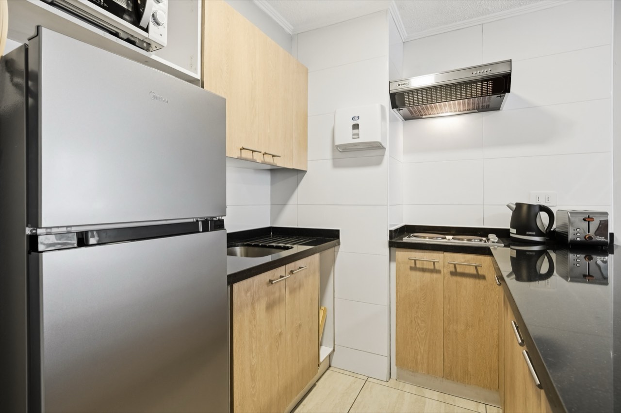 Cocina con refrigerador y electrodomésticos - Suite 106 Suites Vitacura