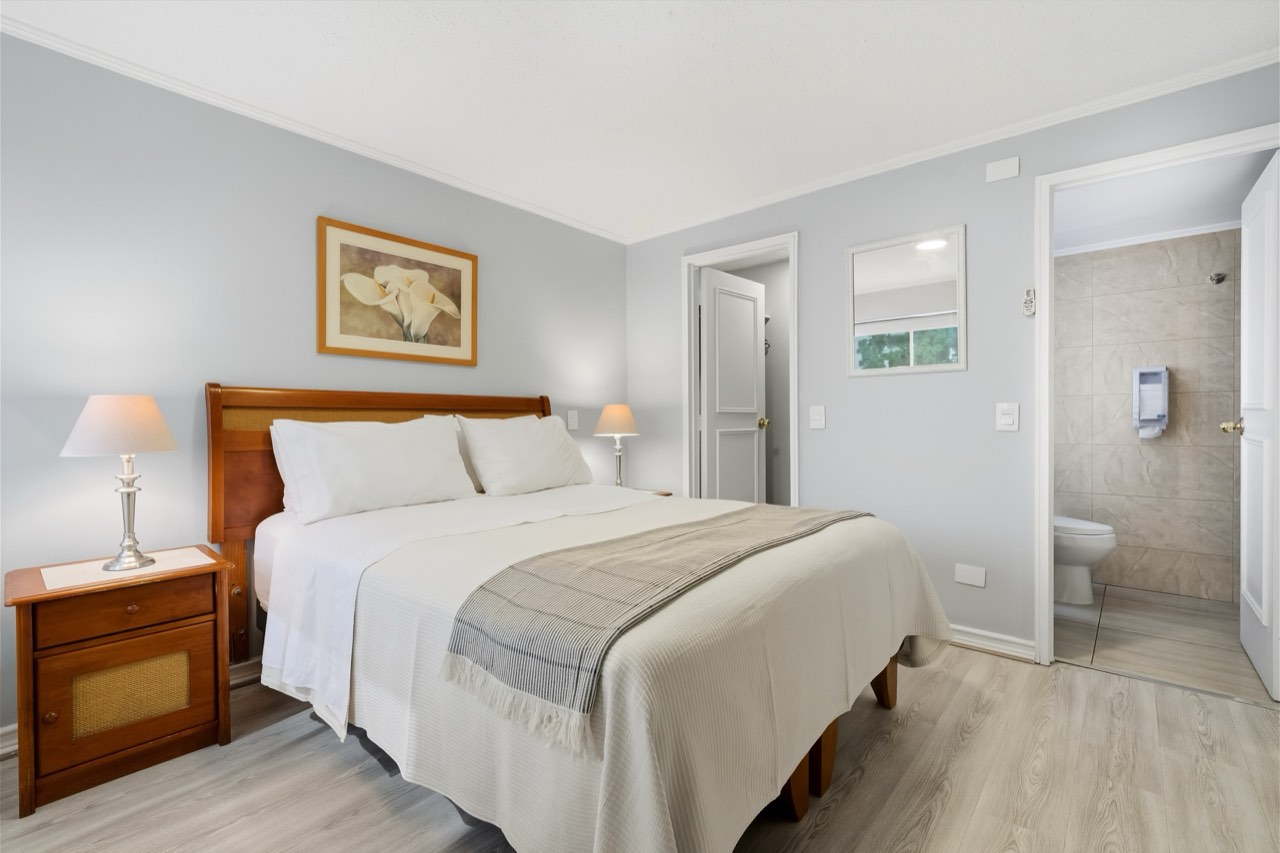Dormitorio con vista al baño en suite - Suite 106 Suites Vitacura