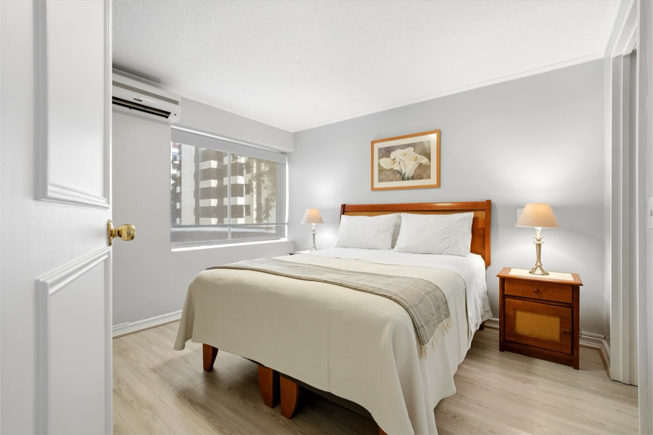 Dormitorio con ventana y aire acondicionado - Suite 106 Suites Vitacura
