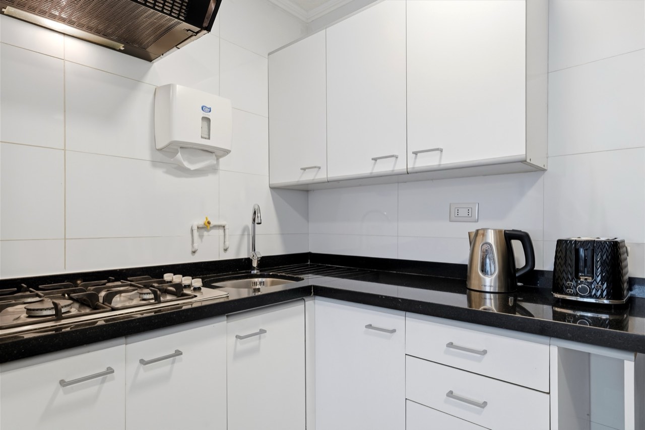 Cocina con encimera y electrodomésticos - Suite 405 Suites Vitacura