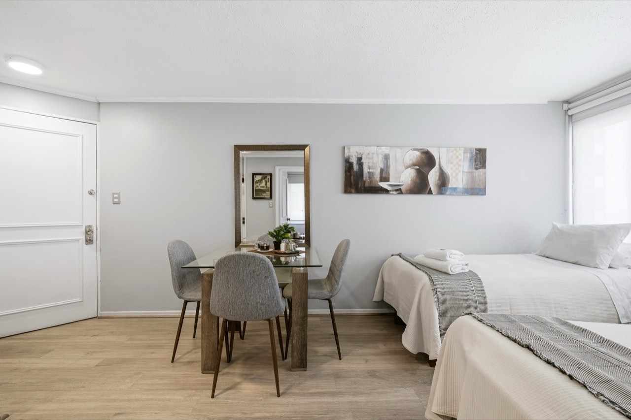 Comedor con espejo y vista al dormitorio - Suite 405 Suites Vitacura