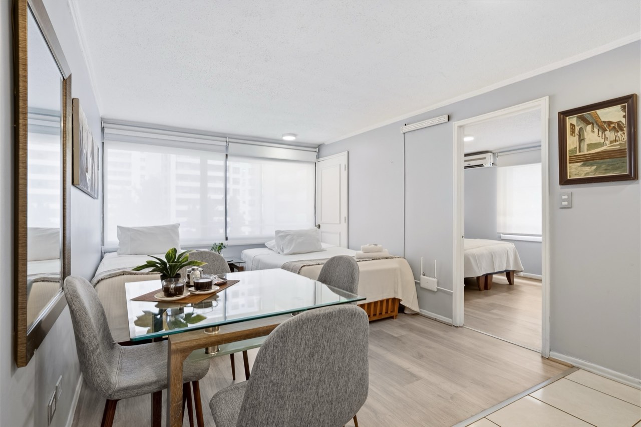 Living comedor con camas y vista al dormitorio - Suite 405 Suites Vitacura