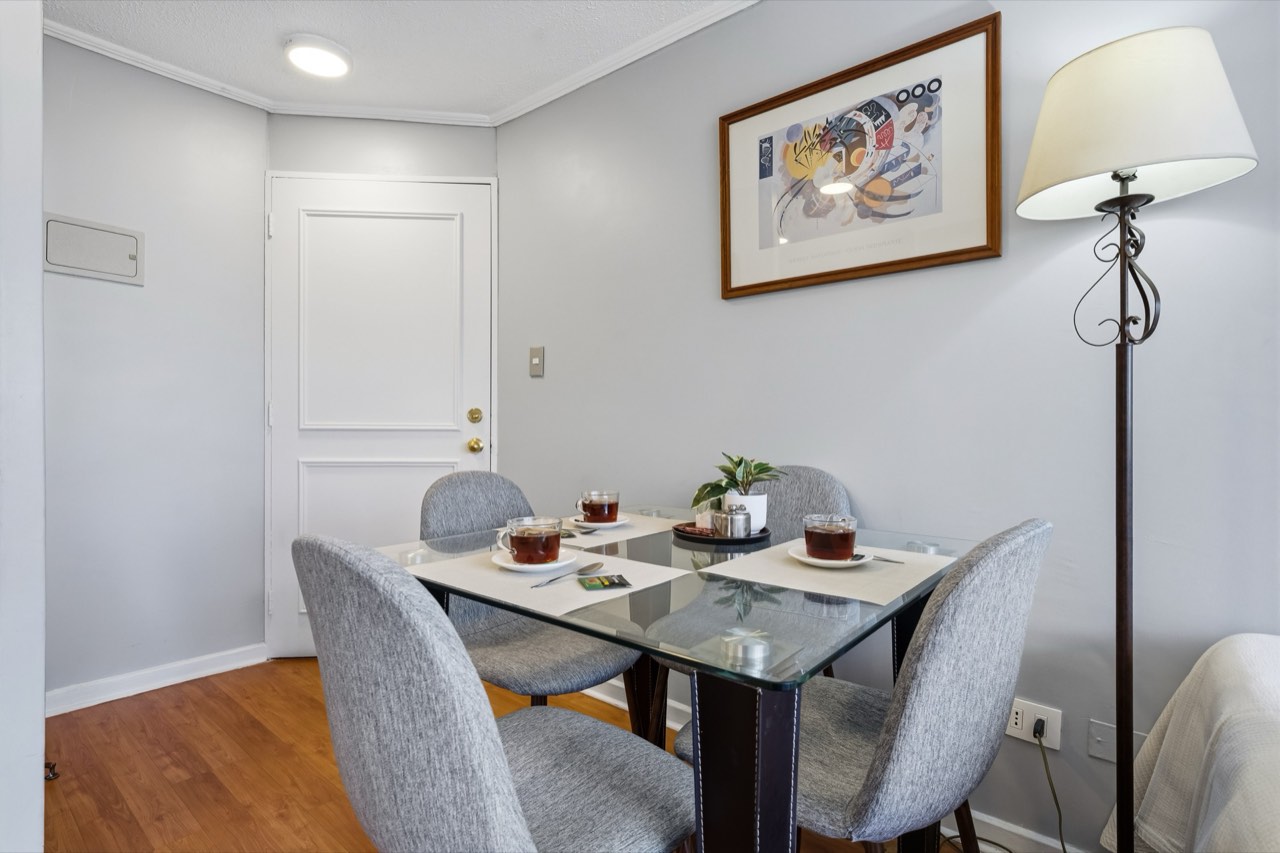 Comedor con mesa de vidrio junto a la entrada - Suite 605 Suites Vitacura
