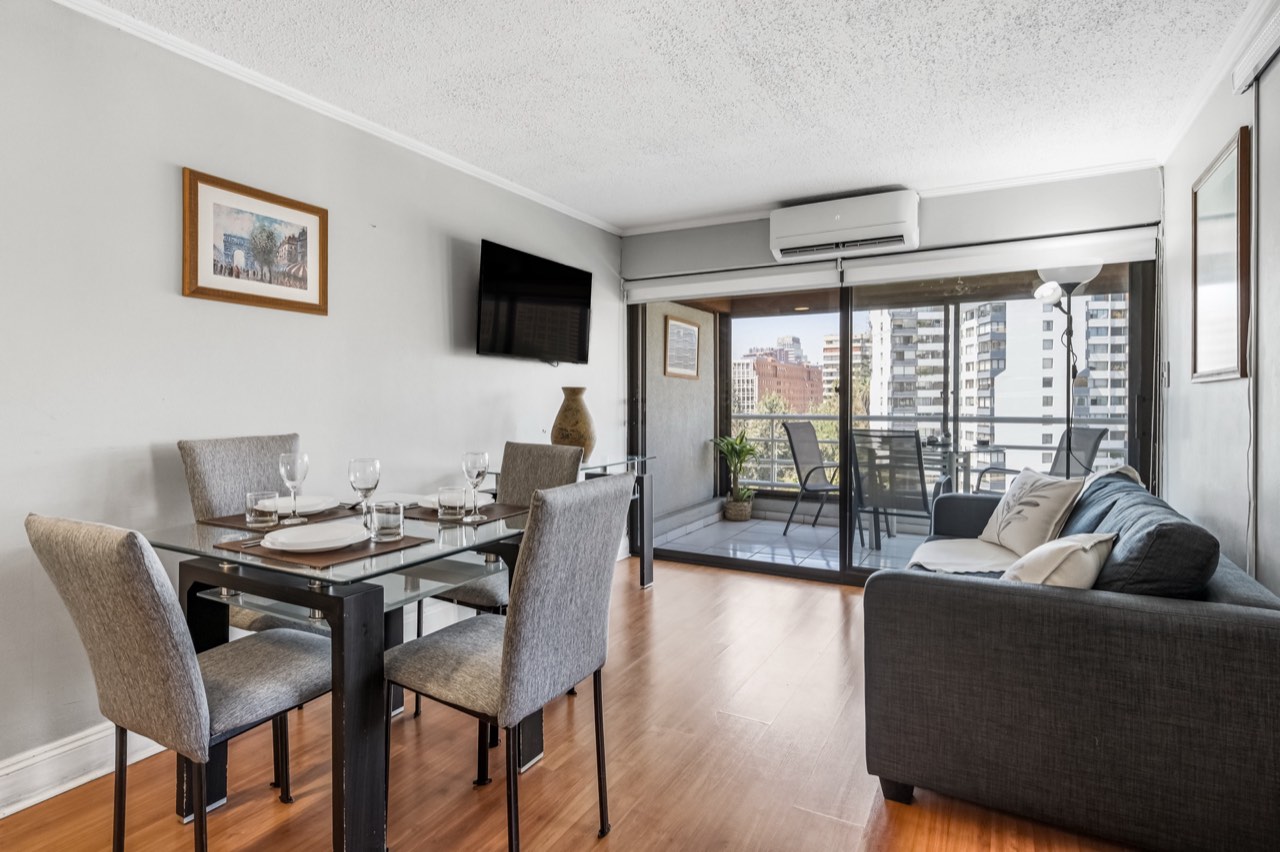 Living con acceso al balcón y vista a la ciudad - Suite 701 Suites Vitacura