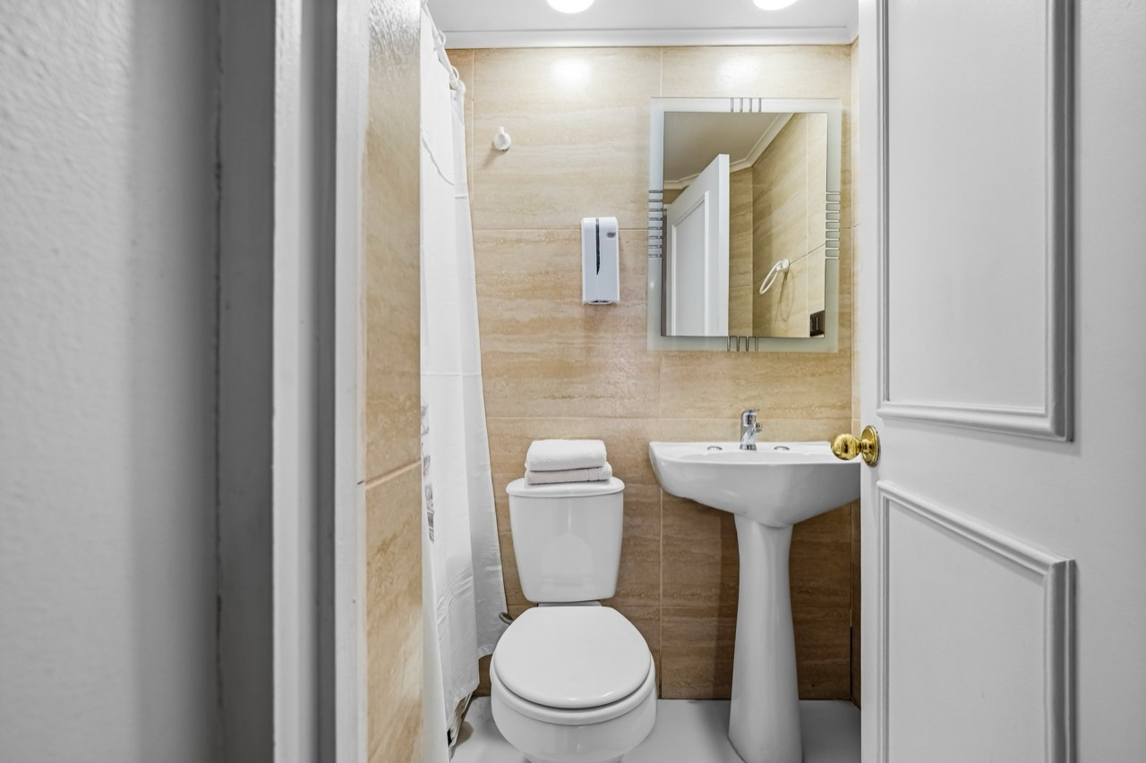 Baño con lavamanos y espejo - Suite 701 Suites Vitacura