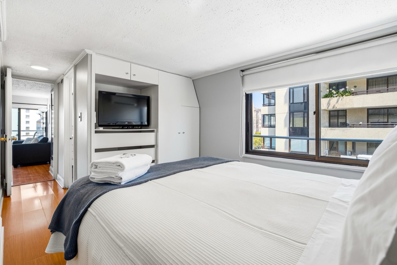 Dormitorio con TV y closet empotrado - Suite 701 Suites Vitacura