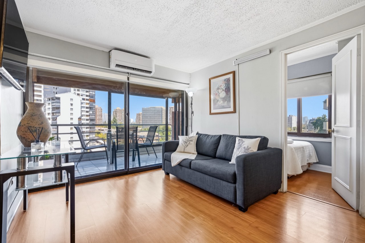 Living con sofá y vista al balcón - Suite 701 Suites Vitacura