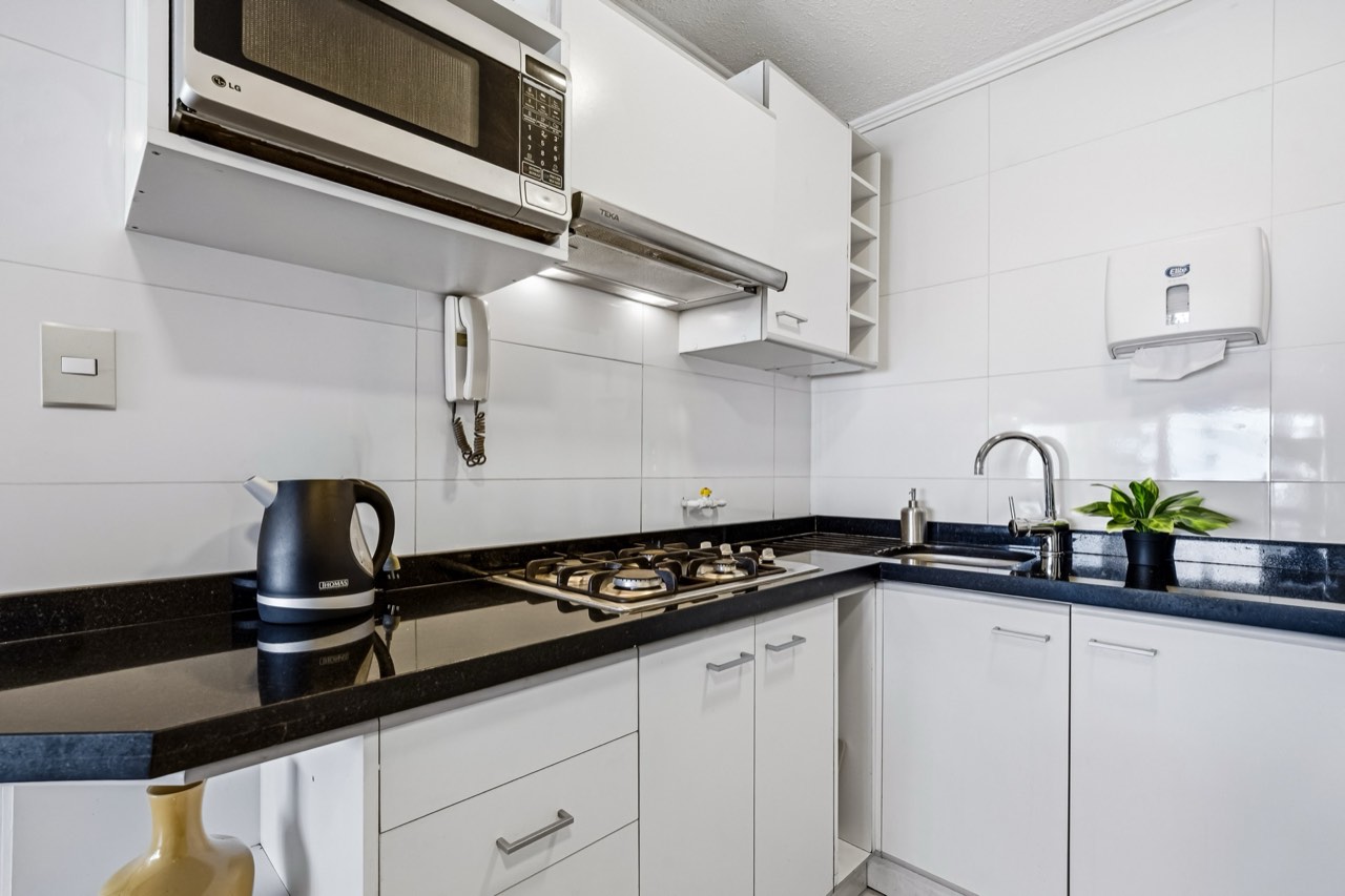 Interior de suite amoblada con living comedor luminoso - Suites Vitacura Vitacura Santiago