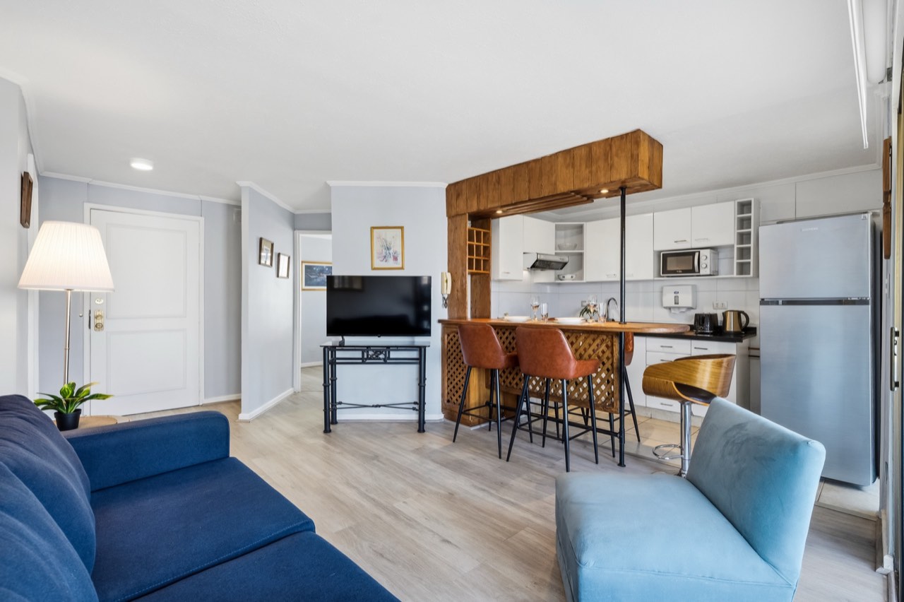 Living con TV y vista a cocina - Suite 801 Suites Vitacura