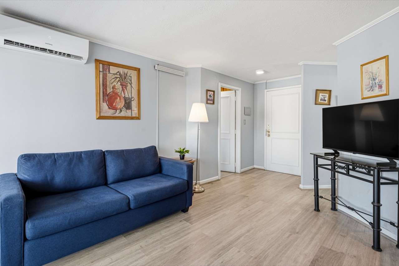 Living con sofá y aire acondicionado - Suite 801 Suites Vitacura