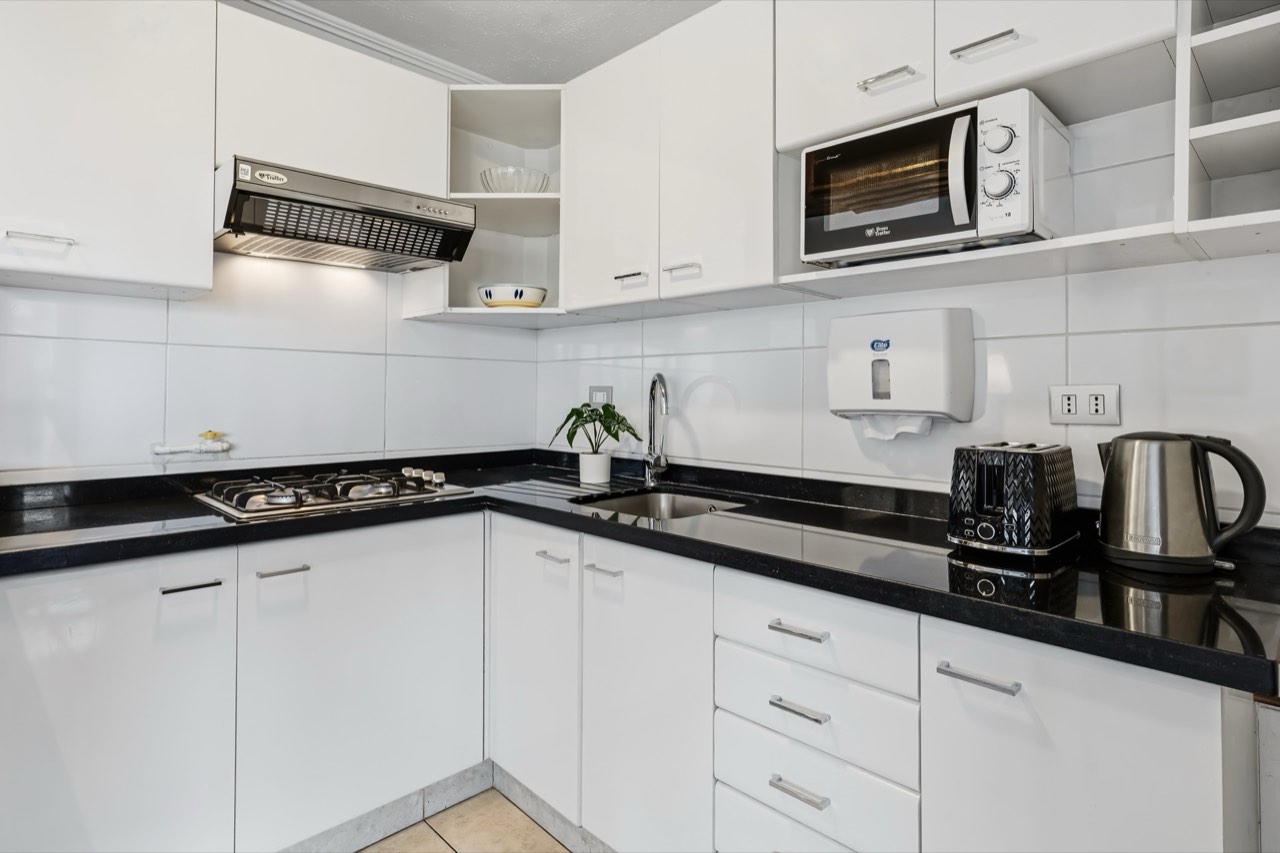 Cocina en L con electrodomésticos completos - Suite 801 Suites Vitacura