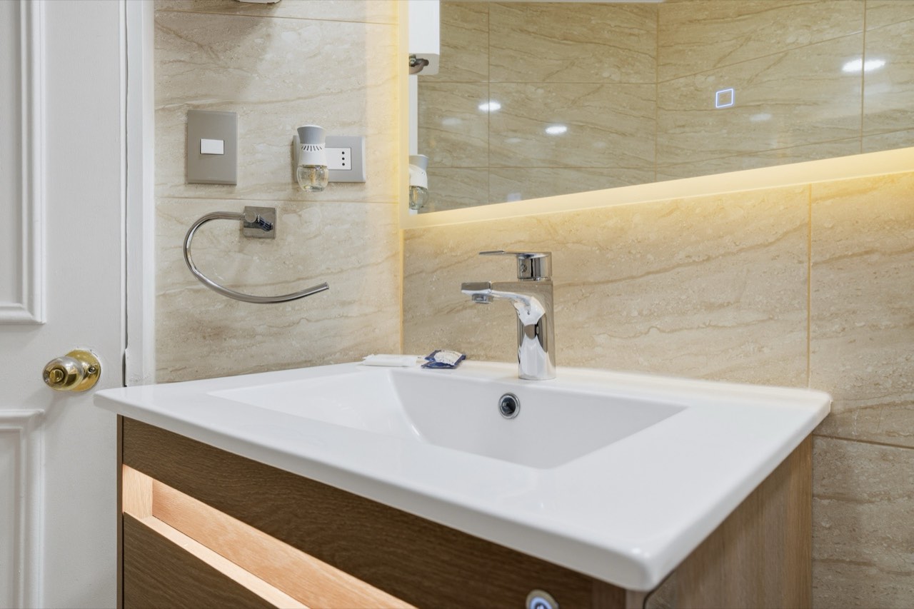 Lavamanos con espejo y grifería - Suite 801 Suites Vitacura