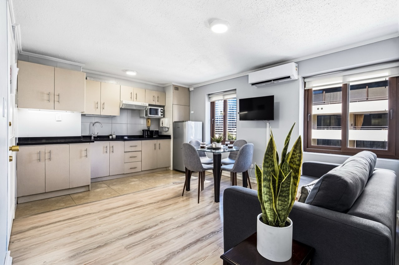 Living comedor integrado con cocina - Suite 803 Suites Vitacura