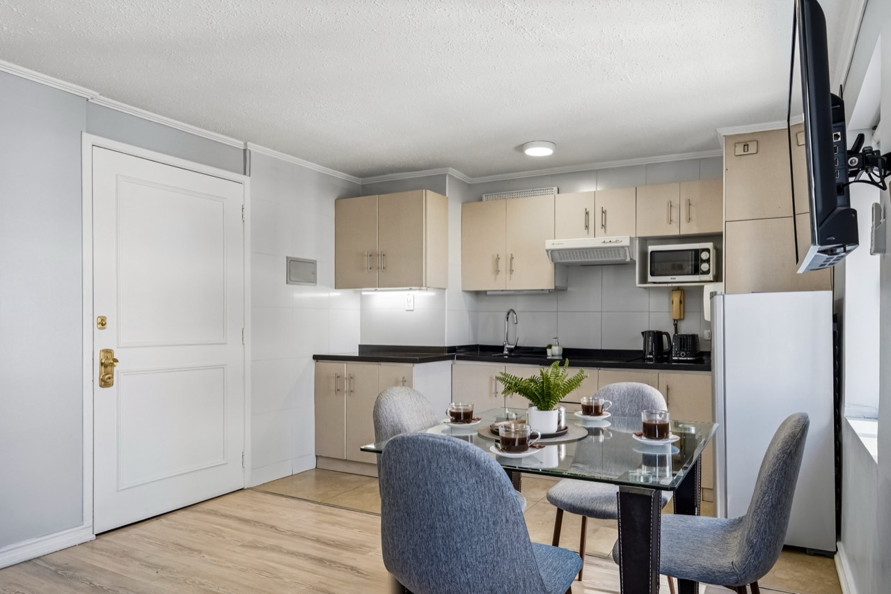 Cocina con comedor y puerta de entrada - Suite 803 Suites Vitacura