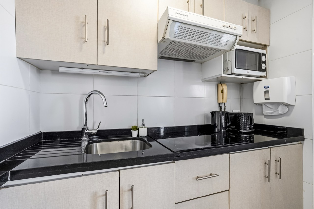 Cocina con detalle de mesón y lavaplatos - Suite 803 Suites Vitacura