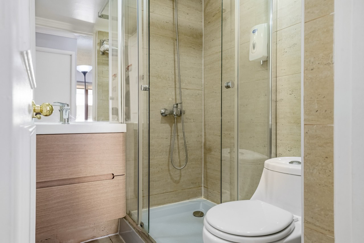 Baño con ducha de vidrio y vanitorio - Suite 803 Suites Vitacura