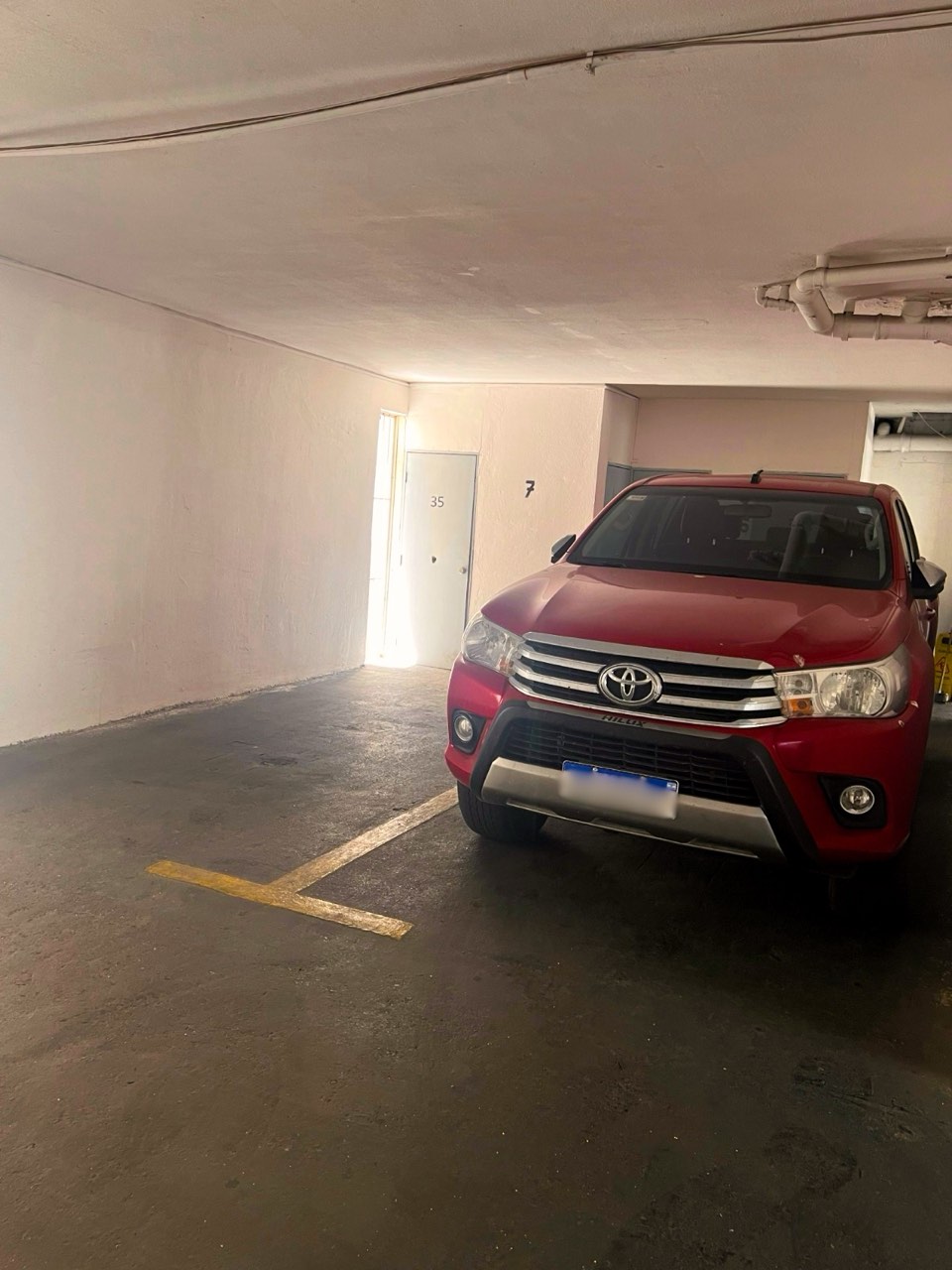 Estacionamiento subterráneo con vehículo estacionado - Suites Vitacura