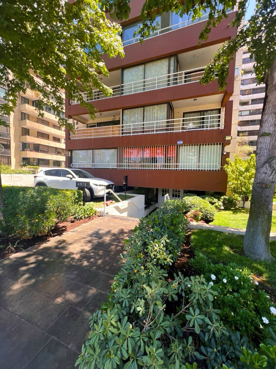 Fachada del edificio con jardines y áreas verdes - Suites Vitacura